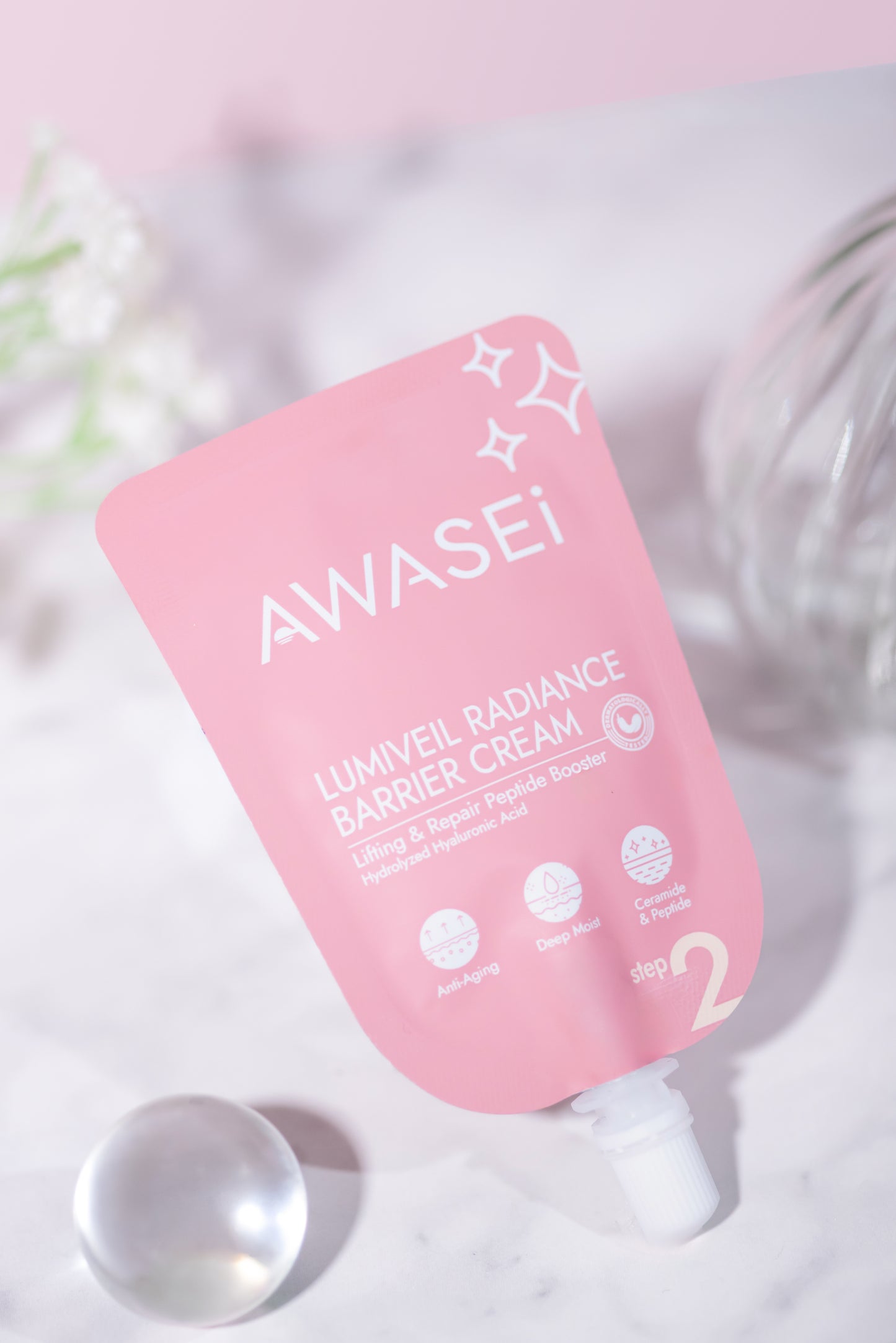 LUMIVEIL Radiance Barrier Cream ซองวางเอียงบนพื้นหินอ่อน ตกแต่งด้วยลูกแก้วใส